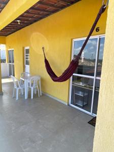 a patio with a hammock on the side of a house at Pousada Dunnas do Thyago - preços de inauguração - Praia de Caraúbas - Vista para o mar e para as dunas in Maxaranguape