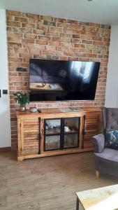 un soggiorno con una grande TV su un muro di mattoni di Hory Opawskie a Głuchołazy
