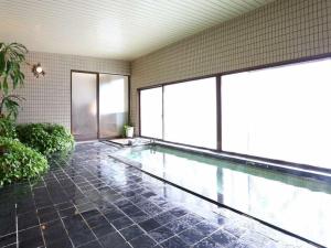 a large swimming pool in a building with windows at Private Villa Utan in Iiyama