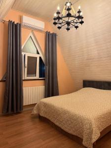 a bedroom with a bed and a chandelier at SkyHouse Shahdag in Əniq +12 photos
