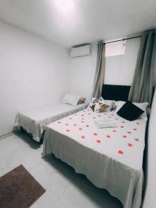 a bedroom with two beds with red hearts on the sheets at Bella Morena 3 - Ilha de Boipeba in Cairu