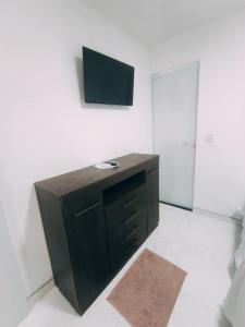 a room with a desk with a television on the wall at Bella Morena 3 - Ilha de Boipeba in Cairu