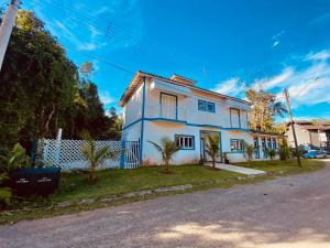 a white house on the side of a street at Casa Verão Guaratuba - Bertioga in Bertioga