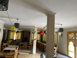 a dining room with tables and chairs and balloons at Itrane sahara Auberge in Taouz