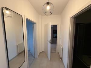 a hallway with a mirror and a hallway with two doors at Oáza Living Mohelnice in Mohelnice