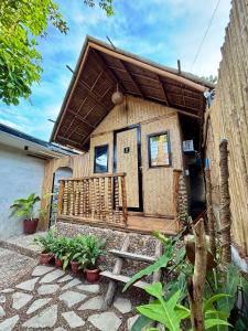 a small house with a wooden roof and a porch at Nipa Hut Lodging House in Coron