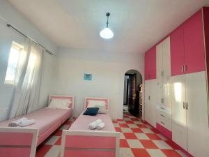 a bedroom with two beds and a checkered floor at Pinkapartment Saranda in Sarandë