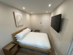 a small bedroom with a bed and a flat screen tv at Santíago Retreat in Wenvoe