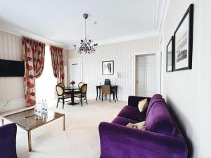 a living room with a purple couch and a table at La Résidence des Trois Couronnes in Vevey