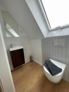 a bathroom with a white toilet and a sink at Urlaubswerft-Dock-13-|-Ihr-stilvolles-Erholungsparadies in Kiel