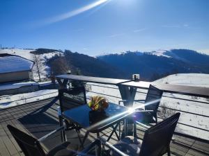 a table and chairs on a deck with a mountain at SUNSET Villa PONIKVA in Kočani
