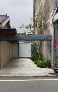 a garage with a blue roof and a building at Spring12 House in Chiayi City