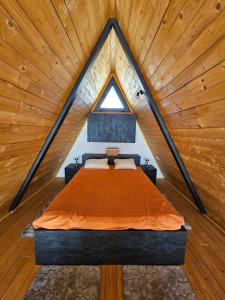 a bed in a room with a wooden ceiling at SUNSET Villa PONIKVA in Kočani +29 photos