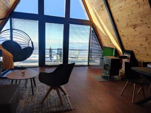 a living room with large windows and a view of the ocean at SUNSET Villa PONIKVA in Kočani