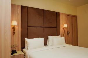 a bedroom with a large bed with white pillows at Hotel The Elite in Jabalpur +49 photos