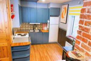 una piccola cucina con armadi blu e lavandino di Gemütliche Ferienwohnung in Nordschweden a Glommersträsk Altre 15 foto