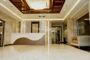 a lobby with a reception desk and a chair at Hotel The Elite in Jabalpur