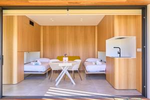 una camera con tre letti e un tavolo con sedie di Villas Calas de Aldan a Aldán