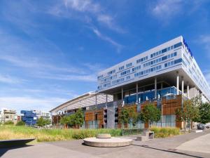 een groot kantoorgebouw met een gebogen dak bij Novotel Lyon Centre-Confluence Bord de Saone in Lyon