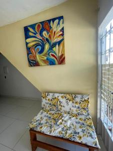 a painting on the wall above a bed in a room at Ster Suítes in Maceió +2 photos