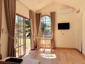 a living room with a television and a chair in front of a window at Napa in Ban Rai Khlong Sai
