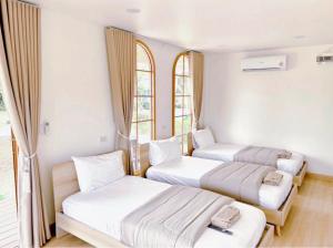 a room with three beds and two windows at Napa in Ban Rai Khlong Sai