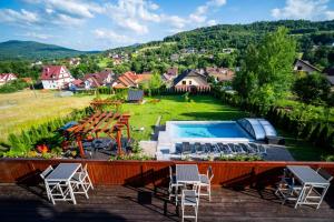 una vista di un cortile con piscina e sedie di Apartamenty Black Lion a Pcim