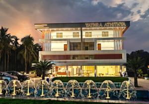 a building with a fountain in front of it at Hotel Yathra Athithya in Dharmastala