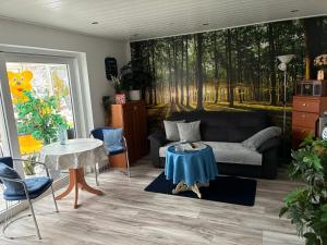 een woonkamer met een bank en een tafel bij Ferienwohnung Gartenblick in Nordenham