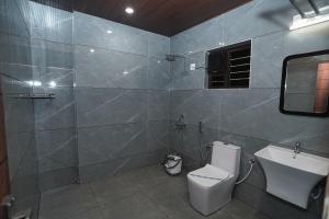 a bathroom with a toilet and a sink and a shower at Hotel Yathra Athithya in Dharmastala +16 photos