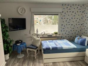 een slaapkamer met een bed, een bureau en een raam bij Ferienwohnung Gartenblick in Nordenham