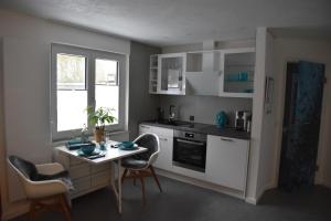 a kitchen with a table and a table and chairs at Moderne Unterkunft mit Wellnessflair in Bodelshausen