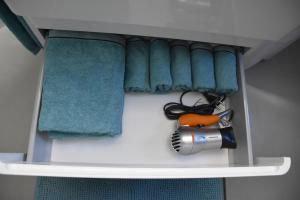 a shelf with towels and a hair dryer and a comb at Moderne Unterkunft mit Wellnessflair in Bodelshausen