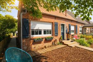 een stenen huis met een raam en een patio bij Huus an`t Dörpsdiek in Krummhörn