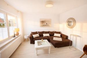 een woonkamer met een bank en een tafel bij Huus an`t Dörpsdiek in Krummhörn +36 foto's