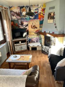 a living room with a couch and a tv at La maison Bellevue in Antignac