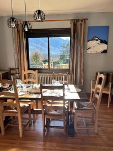 a dining room with a table and chairs and a window at La maison Bellevue in Antignac +28 photos