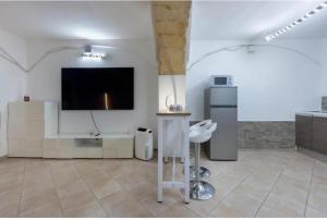 a living room with a flat screen tv on a wall at Sa domu pitticca Cavour in Cagliari
