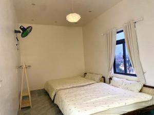 a bedroom with two beds and a window at Gạo homestay Dốc lết in My Luong