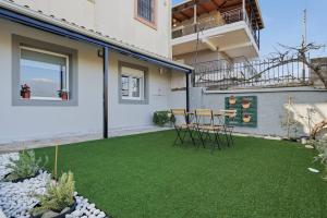 a patio with green grass in front of a building at Calma Ioannina Apartment in Ioannina