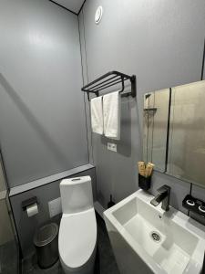 a bathroom with a white toilet and a sink at Home Inn Hotel in Almaty +18 photos