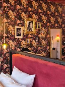 una camera con letto rosa e parete floreale di Hotell Onyxen, boutique- & lifestyle, Adults Only a Göteborg