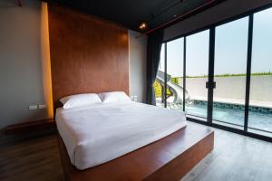 a bedroom with a large bed and a swimming pool at The Brick Huahin Pool Villa in Hua Hin +49 photos