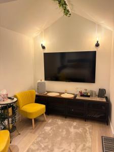 a living room with a large television on a wall at The Cozy Forge in Horley