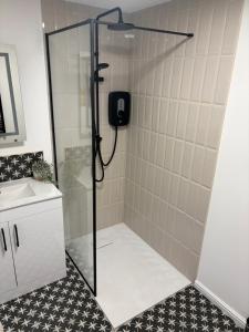 a shower with a glass door in a bathroom at The Cozy Forge in Horley +3 photos