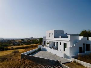 a white house on top of a hill at Naxos Black Concept Maisonette in Naxos Chora