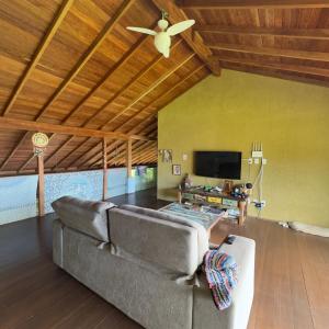 a living room with a couch and a ceiling fan at Pousada Alma da Gamboa in Gamboa