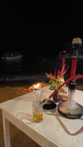 a table with a fire in front of a table with a candle at Seasong Rooms in Unawatuna