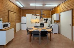 a kitchen with a table and some white appliances at Kolbackens Camping & Stugby in Åsarne