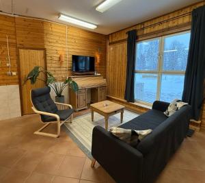 een woonkamer met een bank en een tv bij Kolbackens Camping & Stugby in Åsarna